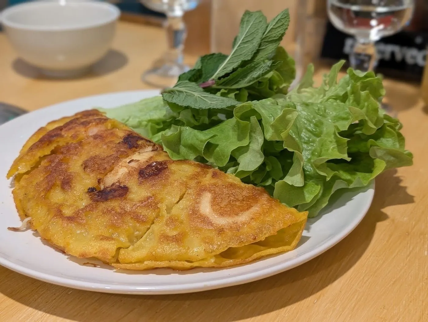 Bánh xèo servi avec salade et herbes fraîches